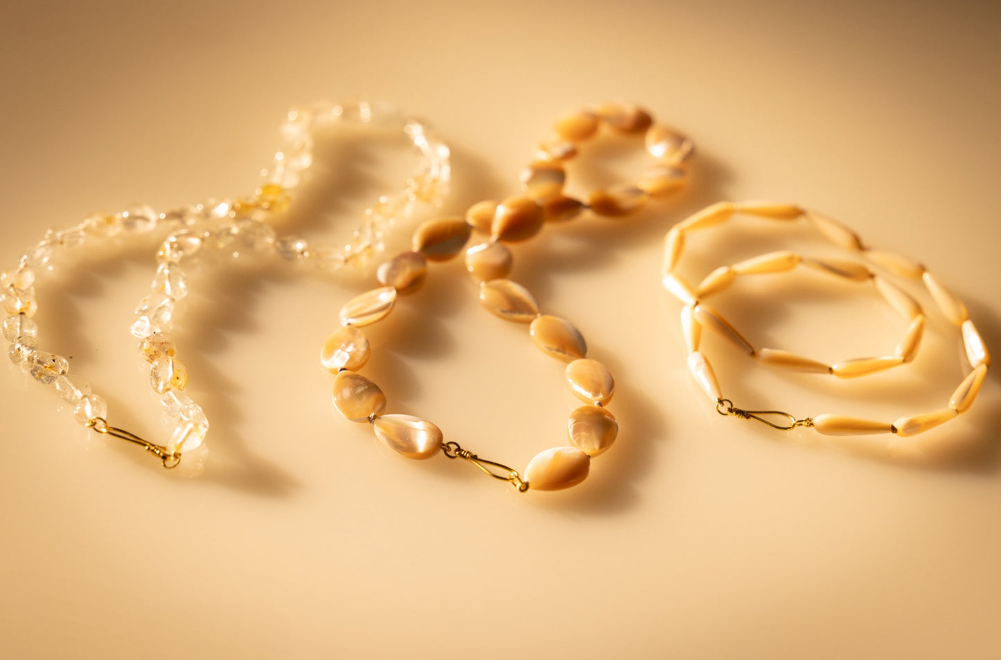 Mother of pearl beaded teardrop necklace alongside 2 beaded necklaces