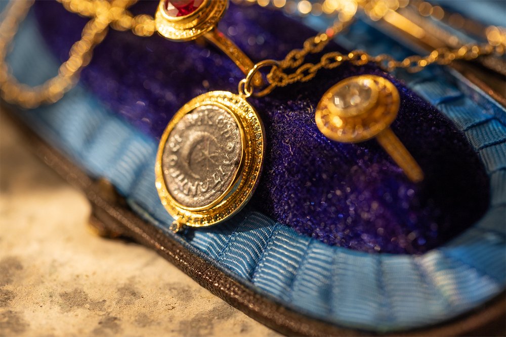22K gold pendant with a Roman coin depicting a crescent moon and six pointed star dazzles with bright blue zircons