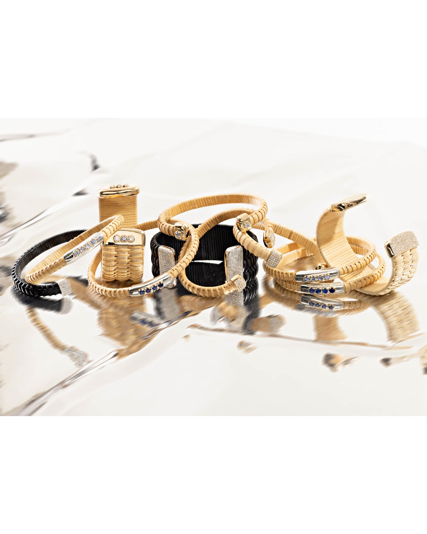 Several cuff and bangle bracelets from the Golden Summer Collection, all handwoven from natural cane and rattan, grouped together.