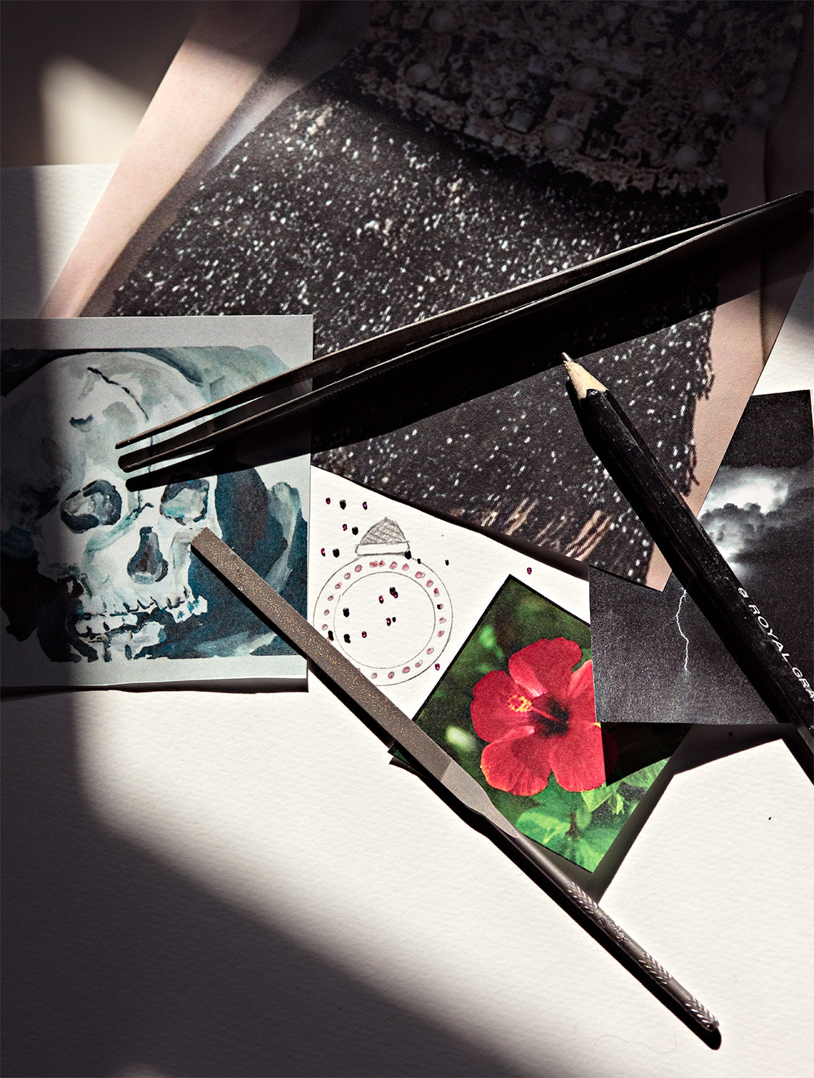 Photographs of a flower, skeleton, and storm with jewelry making tools laying on top