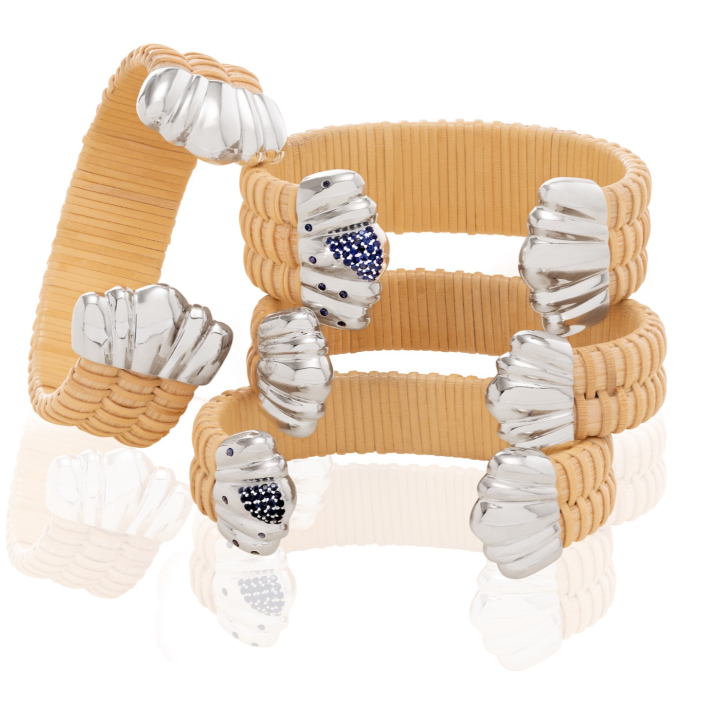 Stack of four cane and rattan weave cuff bracelets with silver scalloped caps and scattered sapphires