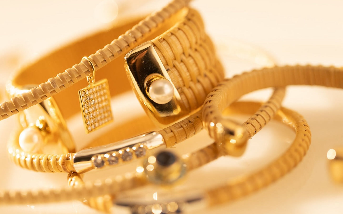 Still-life image of basket-woven jewelry from the Golden Summer Collection.