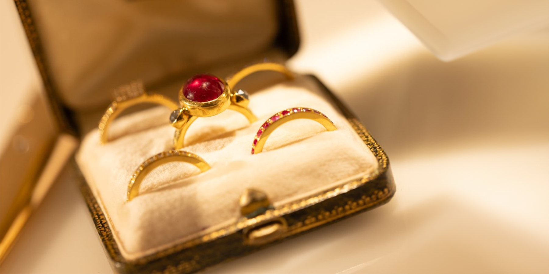 Box of gold rings with red gemstones