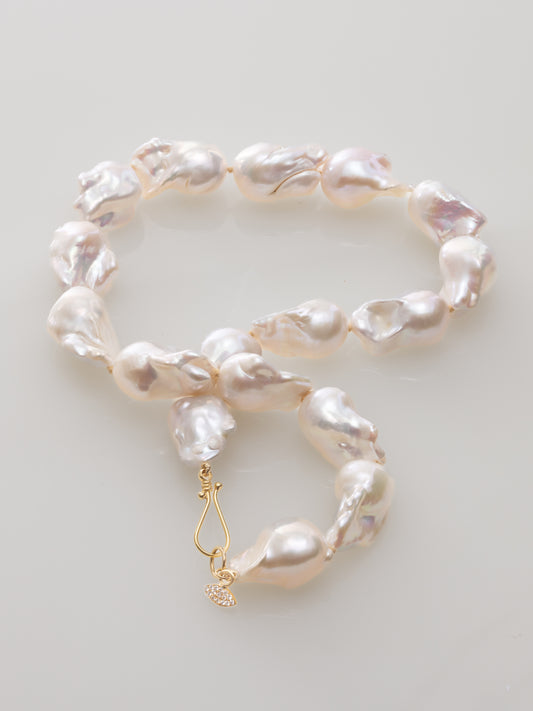 Baroque pearl necklace with a gold clasp and diamond marquise charm