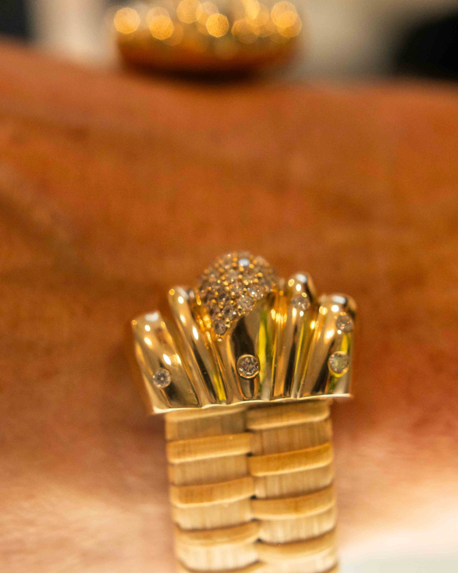 close up of nantucket lightship basket cuff with gold scallop caps and diamonds on wrist