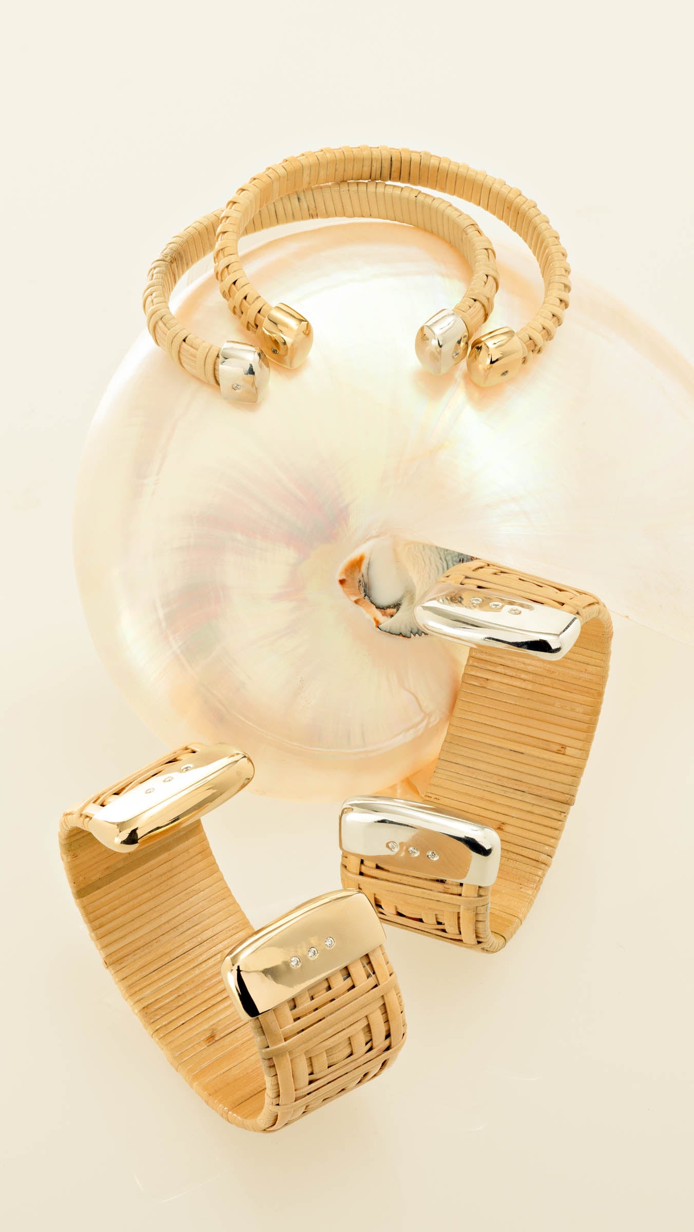 Two Silver Nantucket Lightship Basket 1" Cuff Bracelets with Sterling Silver & Diamond Caps and two 1/4" Nantucket Cuffs on top a seashell