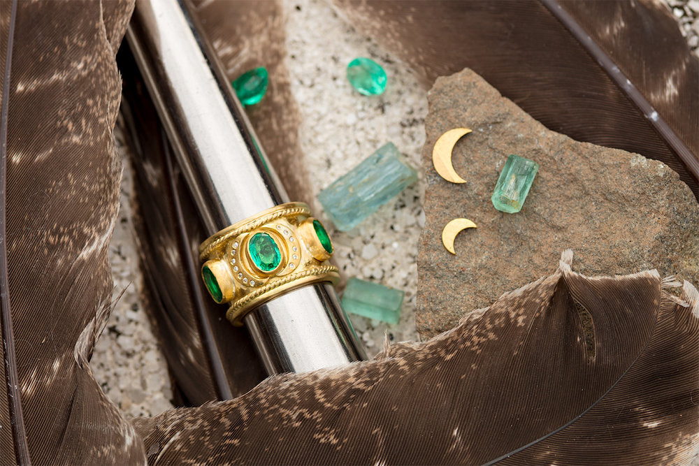 Gold & Emerald Ring surrounded by green crystals and stone