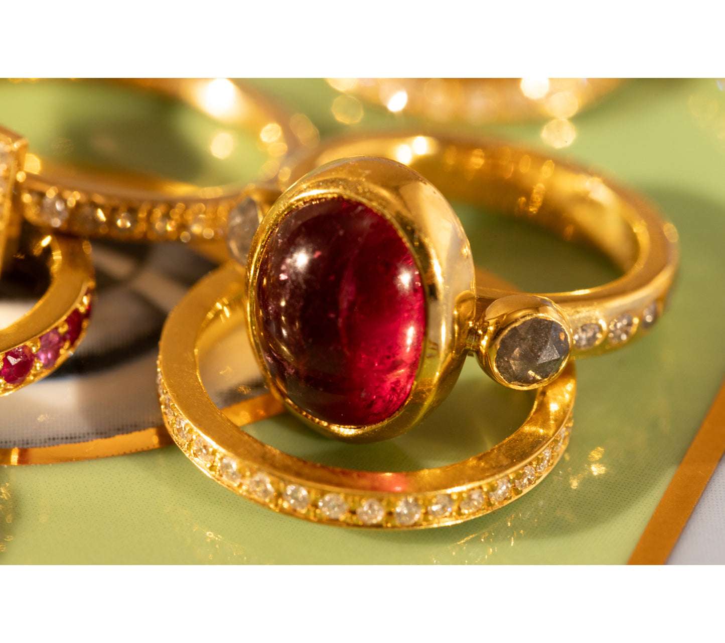 Close up of gold and ruby ring with other gold rings