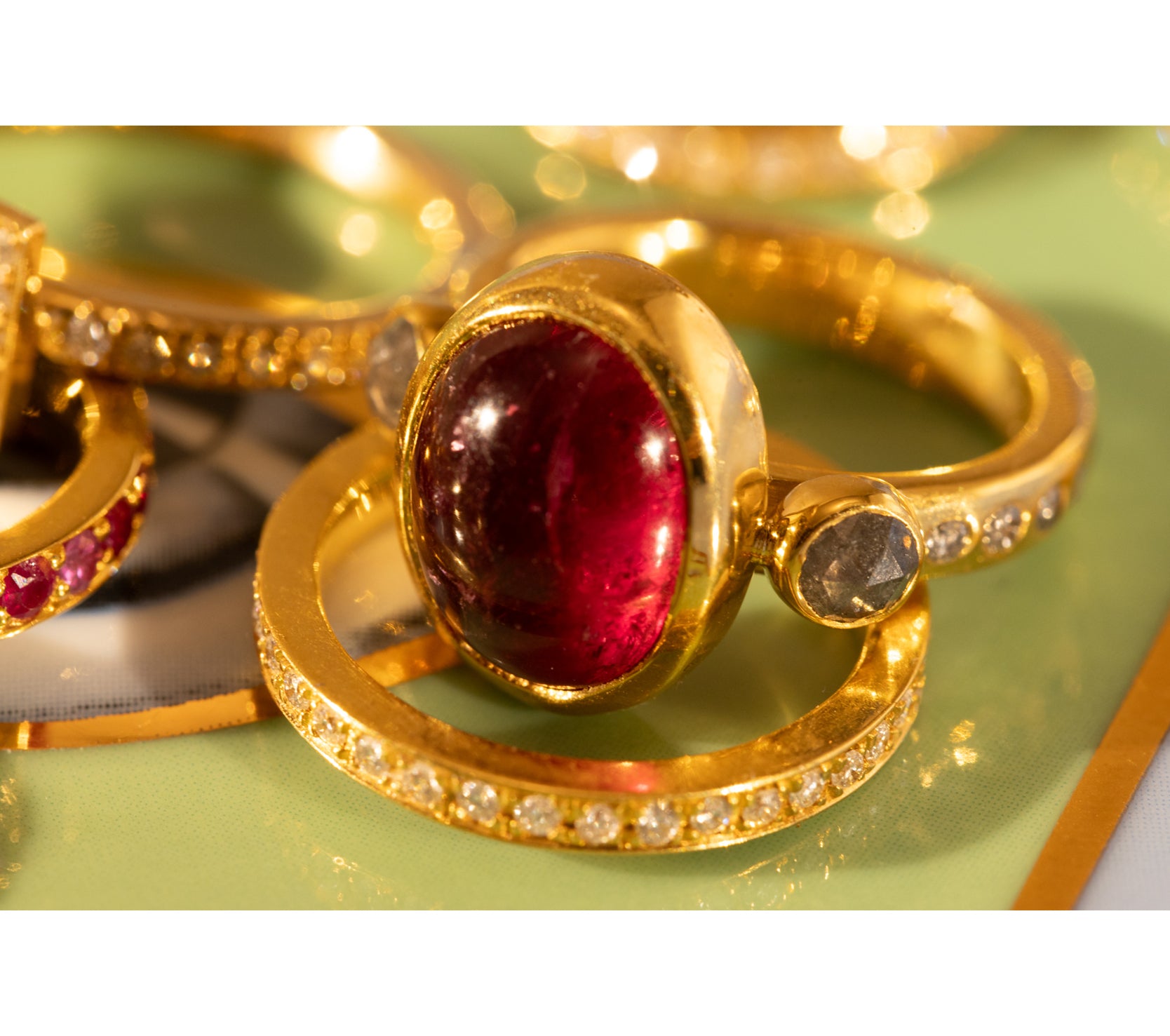Close up of gold and ruby ring with other gold rings