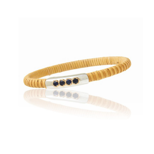 Woven bangle with silver section featuring blue stones on a plain background