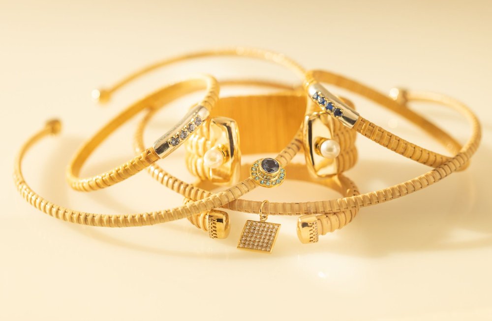 Stack of 1/4" and 1" Nantucket Basket Bangles and cuffs, handwoven from natural cane and rattan, featuring different gems.