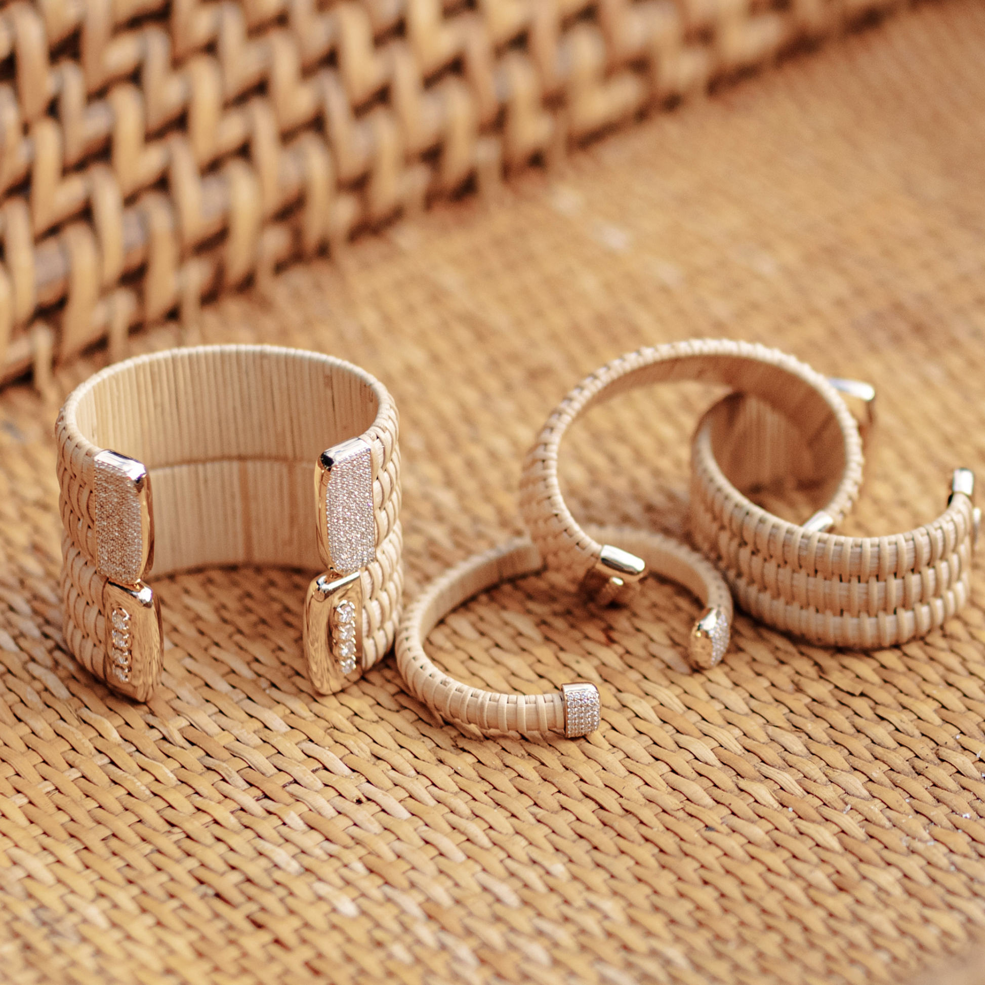 multiple woven cuff bracelets on bottom of woven basket