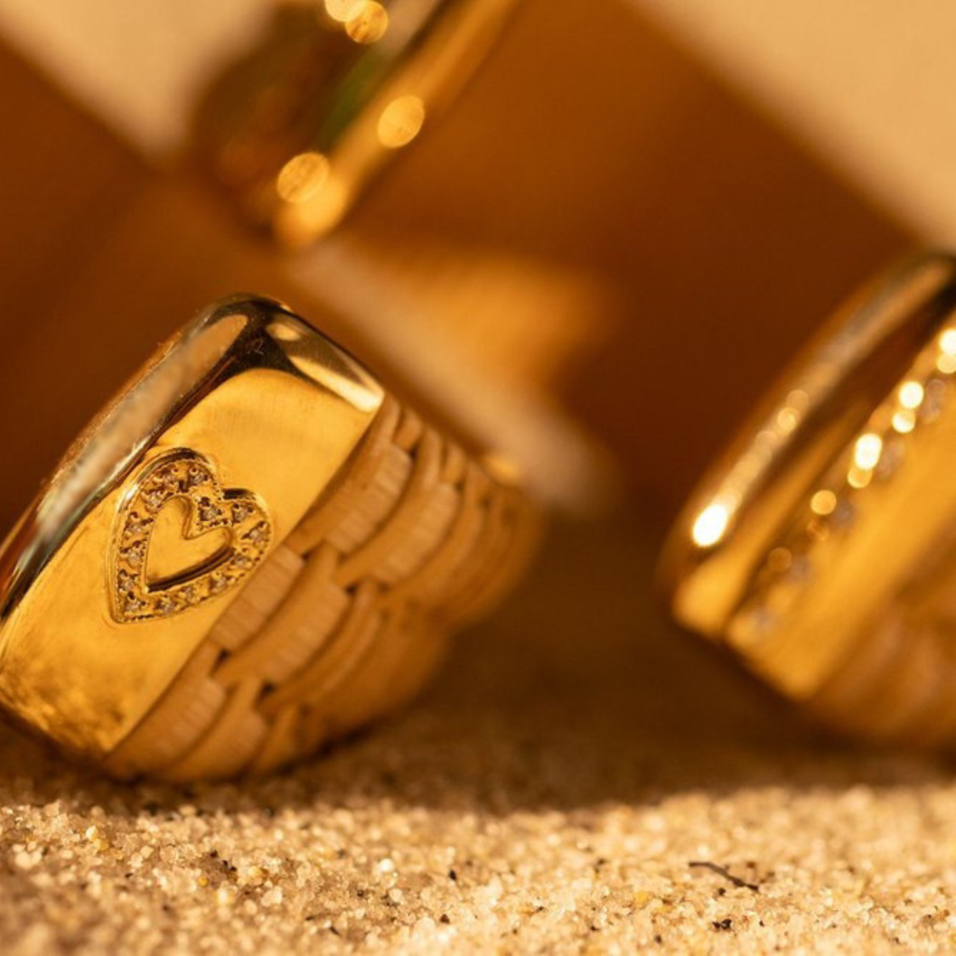 close up of woven cuff bracelets with gold caps and diamond heart accents