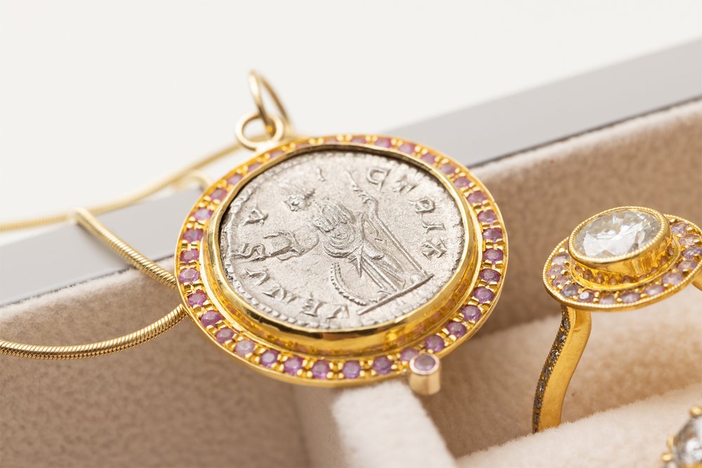  22K gold pendant with an antique silver Roman coin depicting the goddess Venus adorned with pink sapphires