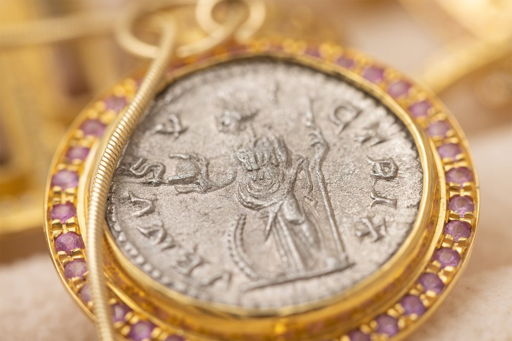  22K gold pendant with an antique silver Roman coin depicting the goddess Venus adorned with pink sapphires