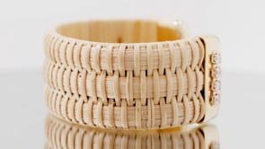 video of 1" Nantucket Cuff bracelet, handwoven from natural cane and rattan, with gold cuffs and diamonds turning on a table